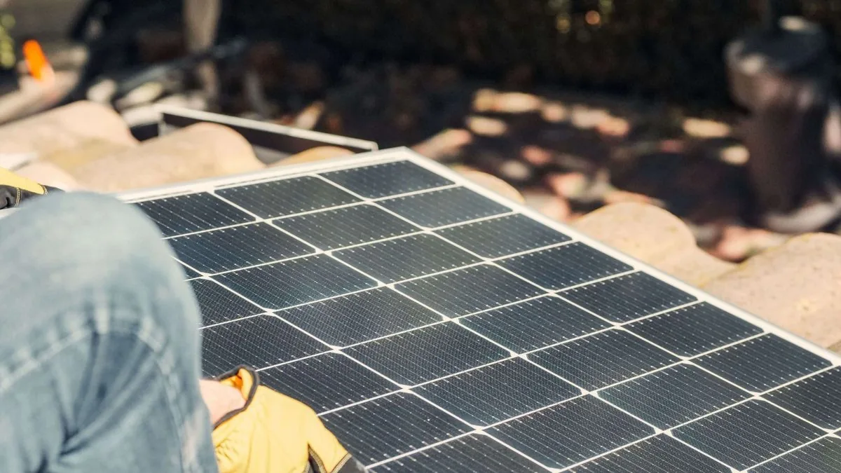 Fachmann mit Unterlagen an einer Solaranlage